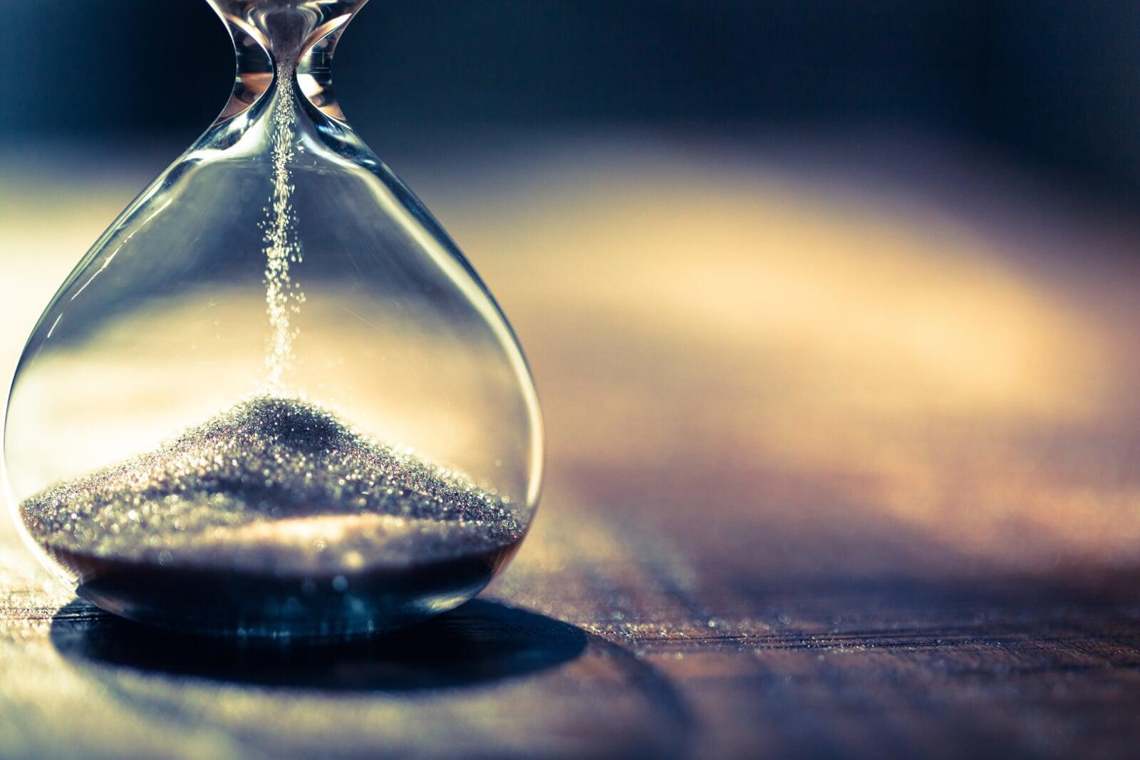 Untere Hälfte einer Sanduhr mit rieselndem Sand